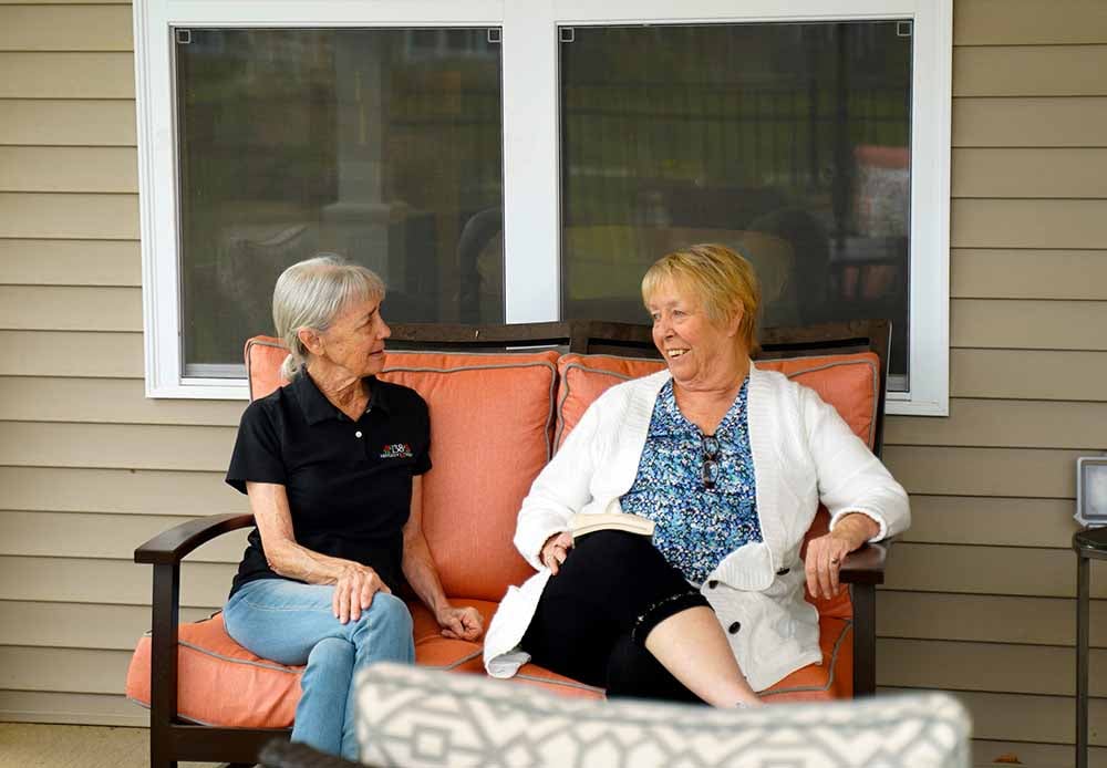 Two women chatting on the porch